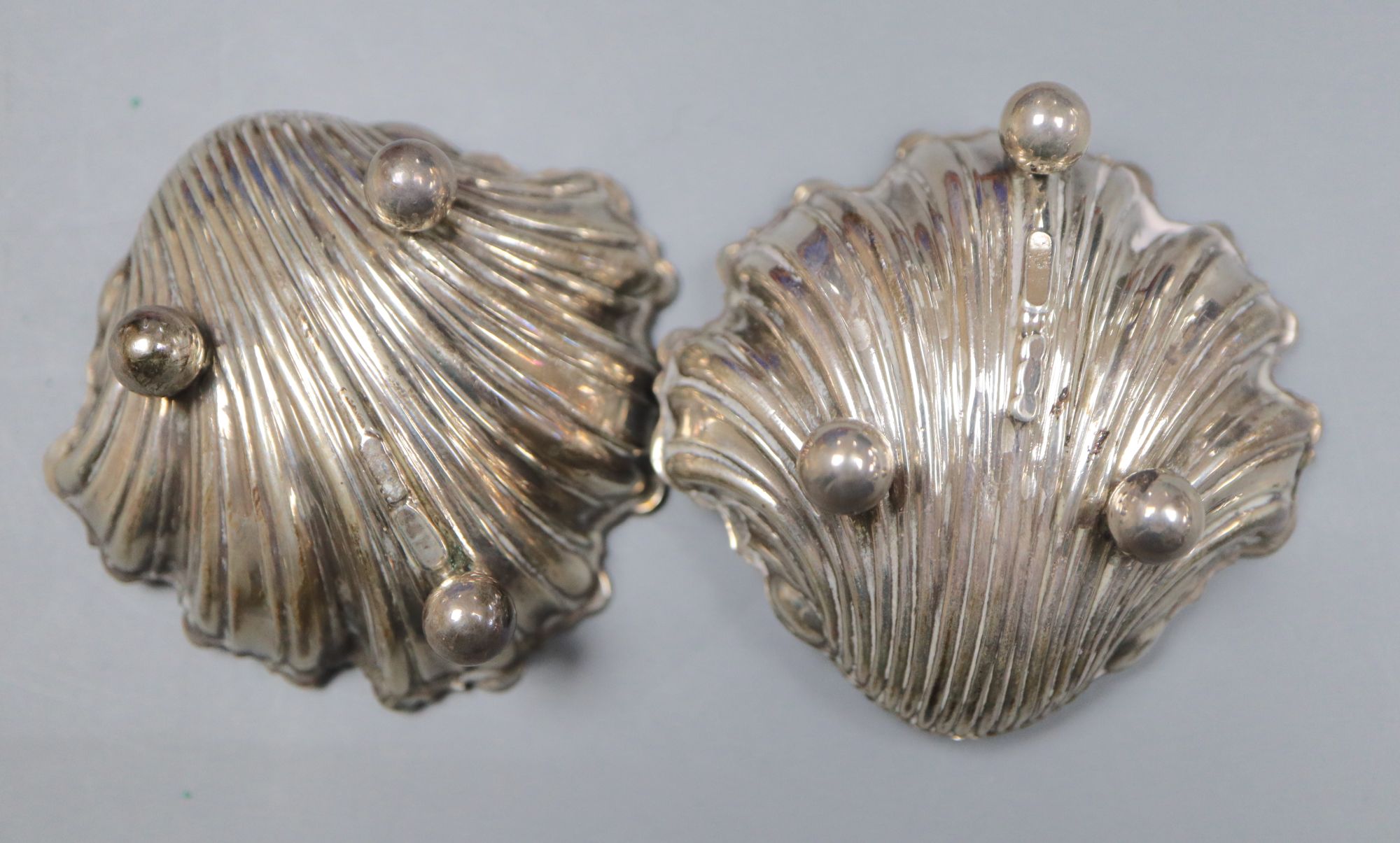 A pair of Edwardian silver shell salts and spoons and a similar twin compartment sovereign case, 61mm